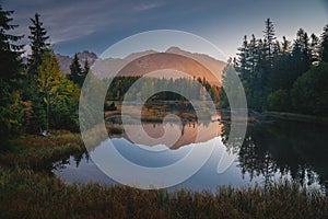 First morning light in mountains. Scenry by lake. Hiking photo. High Tatras, Slovakia