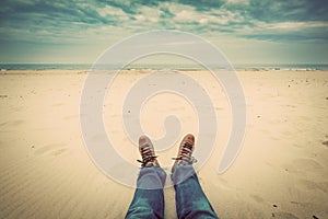 First person perspective of man legs in jeans on the autumn beach