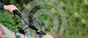 First-person view bicycle riding. Man riding a bike. Summertime outdoor leisure sport activity. Close up of bicycle handle bar