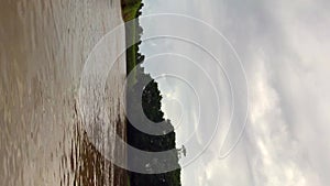 First-person view of boat navigation on a river in Tortuguero National Park, Costa Rica, on a cloudy day.