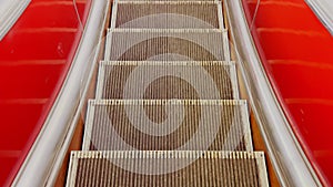 First person view of close up footage of moving empty escalator stairs, escalator moves steps down