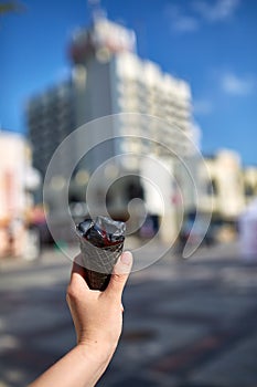 A first person view, girl walking along the road with an ice cream in her hands, shallow depth of field.