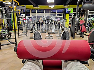 First person view of leg day exercise for heavy weight lifting and body building in a well equipped and modern gym interior