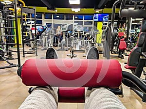 First person view of leg day exercise for heavy weight power lifting and body building in a well equipped and modern gym interior
