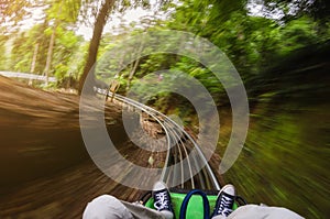 First person view of a man riding a rollercoaster cart in jungles. Motion blurred