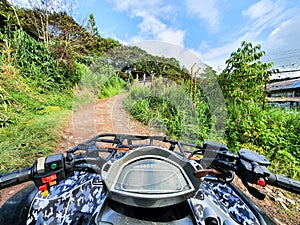 First person view in the middle of the jungle, ATV driver in the mud. Adventure trip in the forest. Soft focus. Man on
