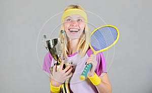 First place. Sport achievement. Celebrate victory. Tennis champion. Athletic girl hold tennis racket and golden goblet