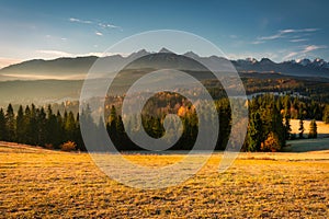 The first rays of the rising sun over the autumnal Tatra Mountains. The pass over Lapszanka. Poland