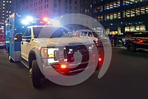 First responder ambulance on urban city street with lights flashing at night photo