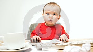 Happy child baby girl toddler sitting with keyboard of computer isolated on a white background