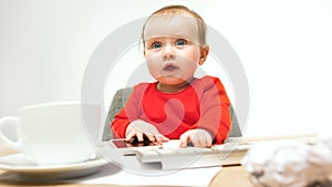 Happy child baby girl toddler sitting with keyboard of computer isolated on a white background