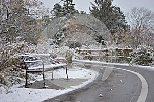 The first snow. Abandoned bench and a road