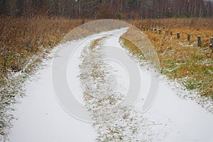 The first snow on the autumn field. Winter. The background of nature. Snow-covered roads