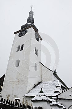 First snow falling on catholic miners gothic church in Spania Dolina, Slovakia