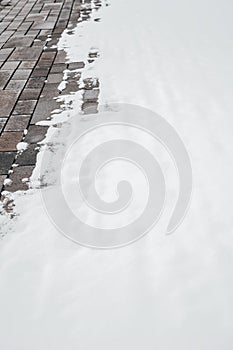 The first snow lies on the paving stones