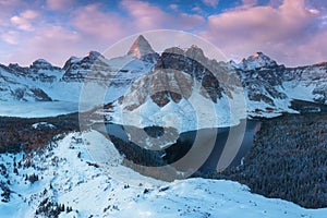 First snow. Mount Assiniboine, also known as Assiniboine Mountain, is a pyramidal peak mountain located on the Great Divide.