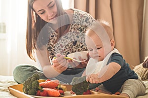 First solid food for young kid. Fresh organic carrot for vegetable lunch. Baby weaning.