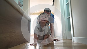 first steps. baby daughter crawls with dad playing on the floor indoors. happy family kid dream concept. father teaches