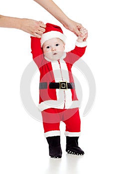 First steps of child baby dressed as Santa claus