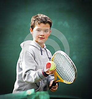 First tennis lessons for the smiling kid with the two colours ball for beginners is ready for a service