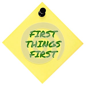First Things First reminder green marker text, crucial business concept,  yellow post-it sticky adhesive note sticker