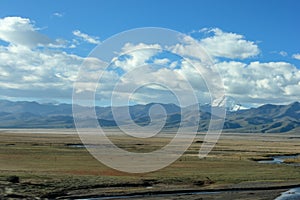 First view on Kailash Mountain rising from Barkha plain from the road from the distance with fields in front