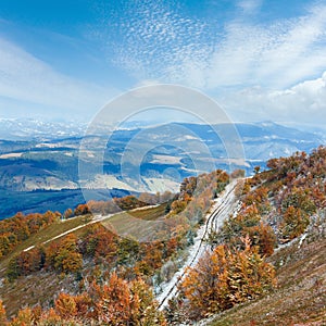 First winter snow and autumn colourful foliage on mountain