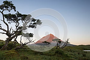 First yellow red sunlight falling onto Ponta da Pico, Portugals highest mountain on Pico Island as seen from Lagoa do CapitÃÂ£o photo