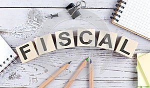 FISCAL text on wooden block with office tools on the wooden background