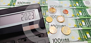 Fiscal year 2023. Calculator on the background of euro coins and banknotes