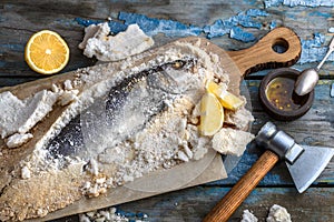 Fish baked in salt with lemon and oil, top view