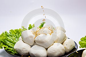 Fish balls ready to be served in a white container.