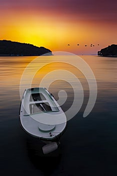 Fish boat on the shore of a sea at sunset