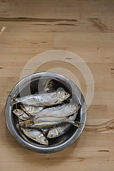 Fish in a bowl herring background wood, in gray brown tones