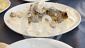 Fish with calamaris in the wine and garlic sauce in the Mediterranian restaurant photo