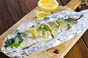 Fish carcass Dicentrarchus labrax with lemon, baked in foil with spices.