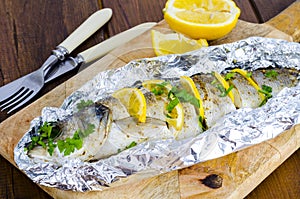 Fish carcass Dicentrarchus labrax with lemon, baked in foil with spices.