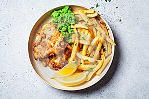 Fish and chips. Cod fish in batter with french fries and mashed peas on a white plate, gray background. English food concept