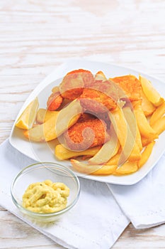 Fish and chips with dip and lemon on white plate