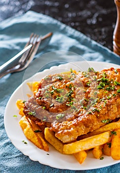 Fish and Chips. Fried fish fillet and potatoes in a white plate