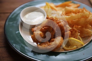 Fish and chips fried fish and potatoes on wood background vintage style