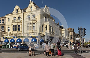 Fish chips and ice cream shops with holidaymakers crossing the street to enjoy.