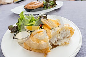 Fish and chips served on a white plate