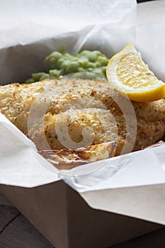 Fish and chips takeaway with mush peas and lemon. Biodegradable eco friendly takeaway cardboard box