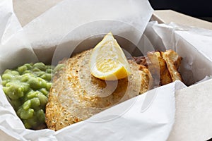 Fish and chips takeaway with mush peas and lemon. Biodegradable eco friendly takeaway cardboard box photo