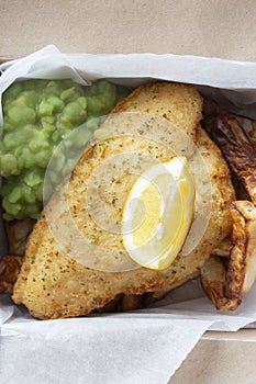 Fish and chips takeaway with mush peas and lemon. Biodegradable eco friendly takeaway cardboard box photo