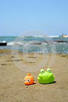 Fish and crab toys on sand