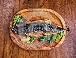 Fish dish with different ingredients on a wooden plate