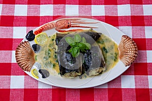 Fish dish top view. Close-up of freshly cooked pieces of European eel fish served on a porcelain plate with a creamy dill sauce