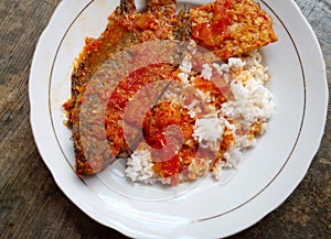 Bali mujair. Bali mujair is tilapia fish cooked with red chili and tomato spices. Usually can be consumed with rice. photo
